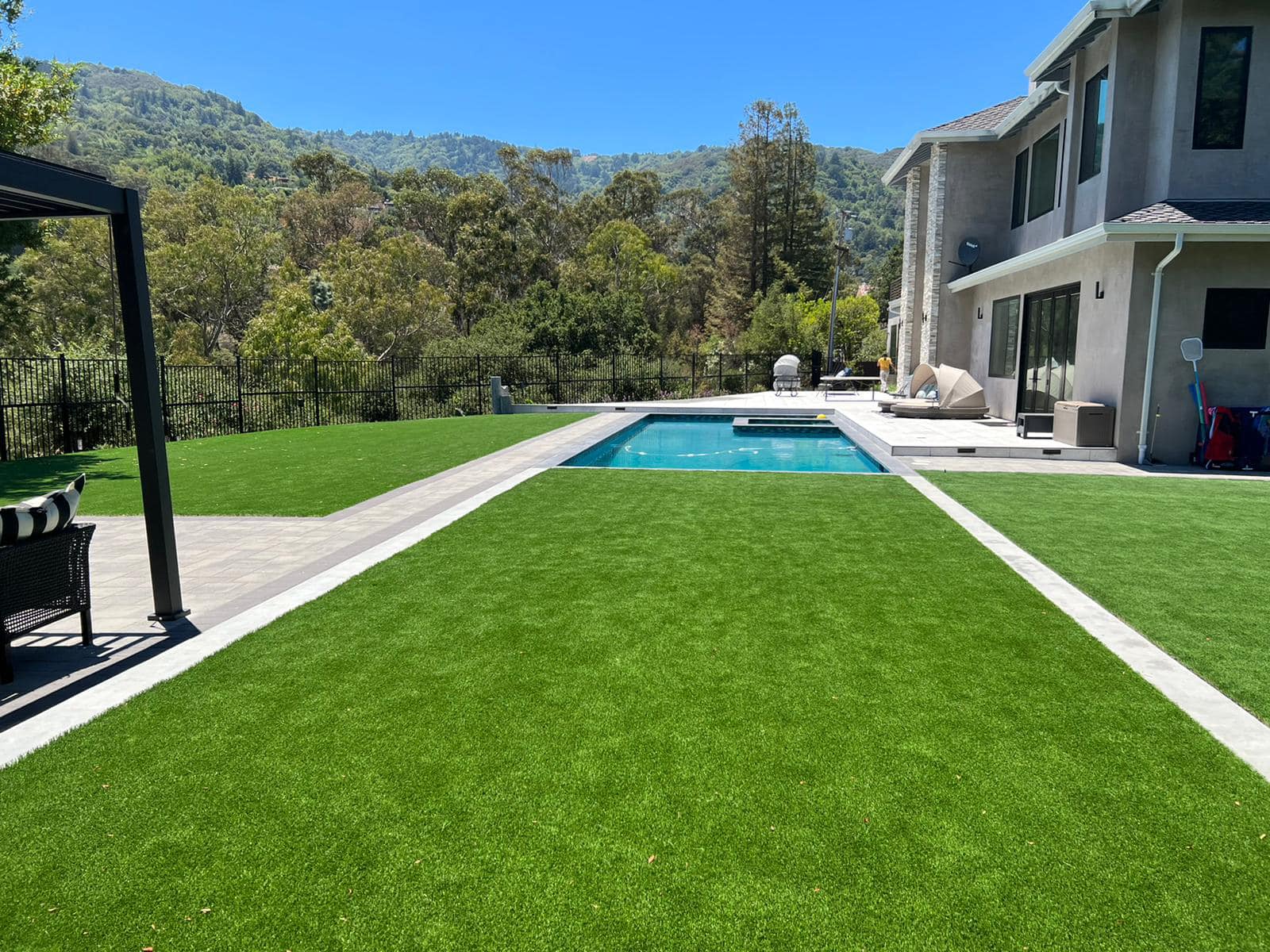 Beautiful backyard with artificial turf surrounding a swimming pool