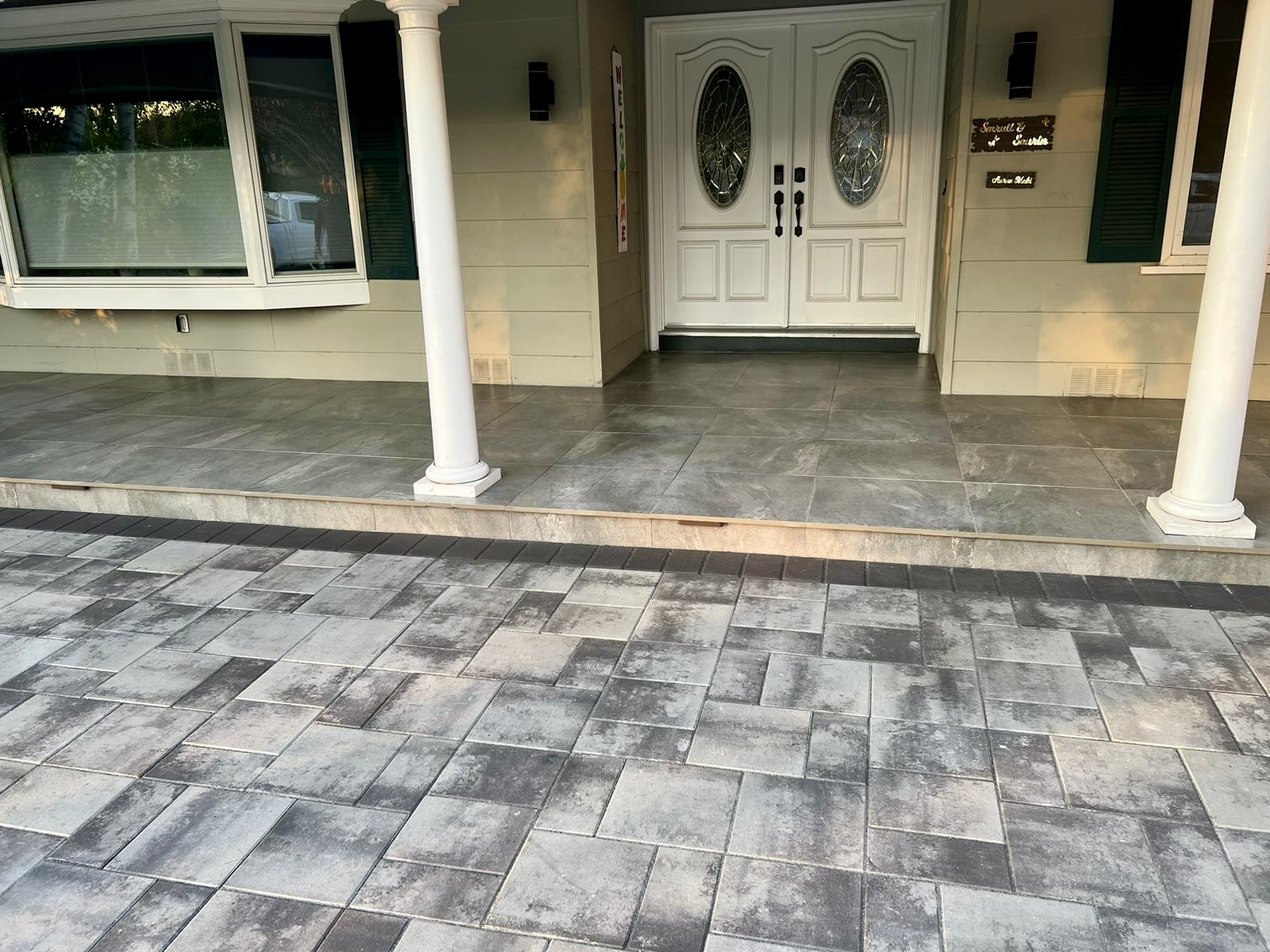 Elegant driveway with premium gray pavers and white columns