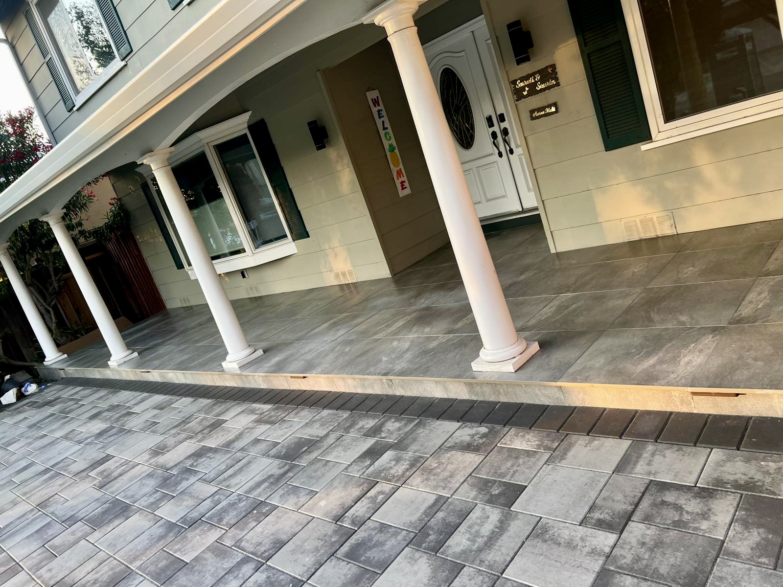 Front entrance with paver driveway and welcome sign