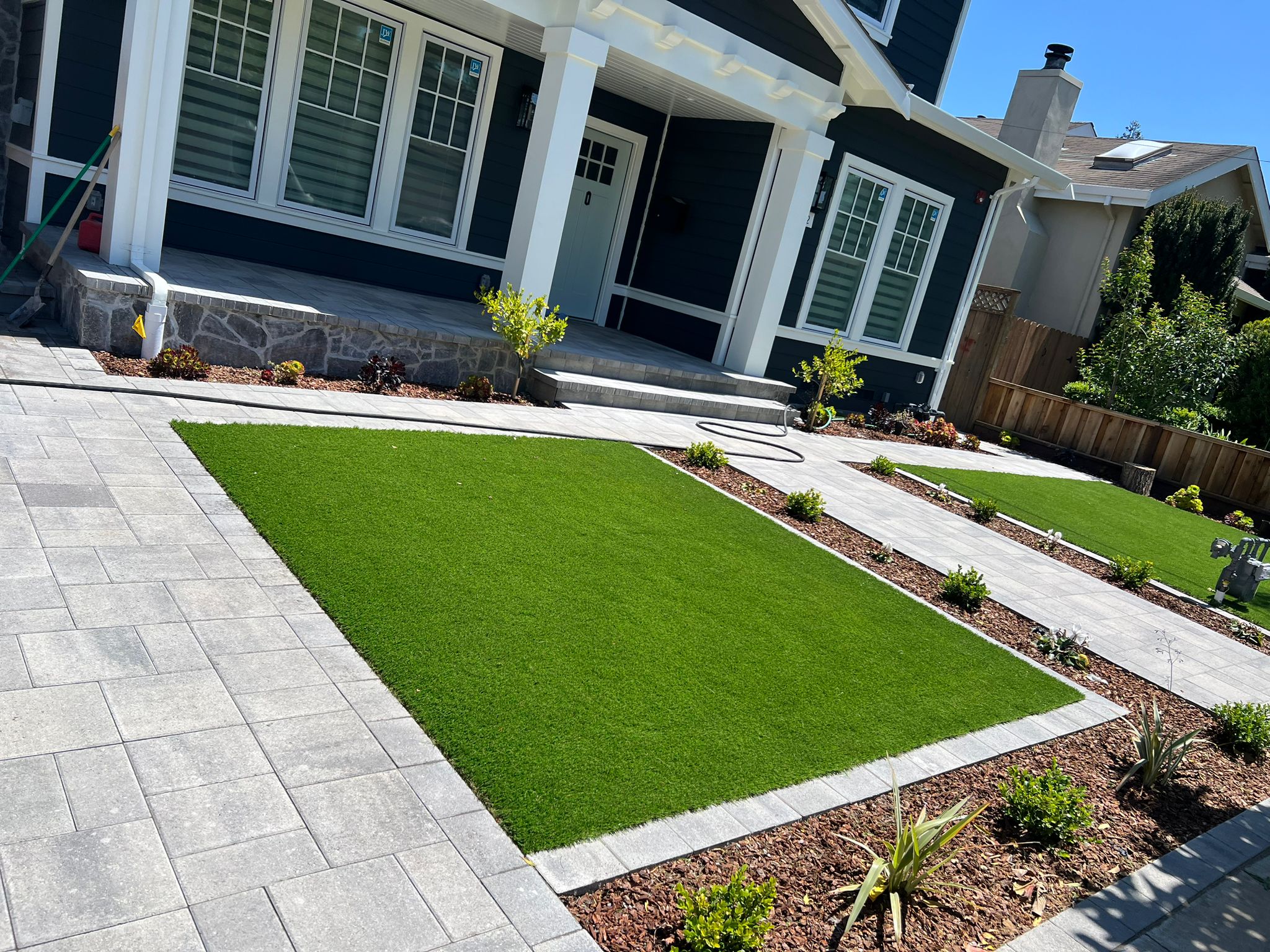 Modern backyard with artificial turf and paver borders