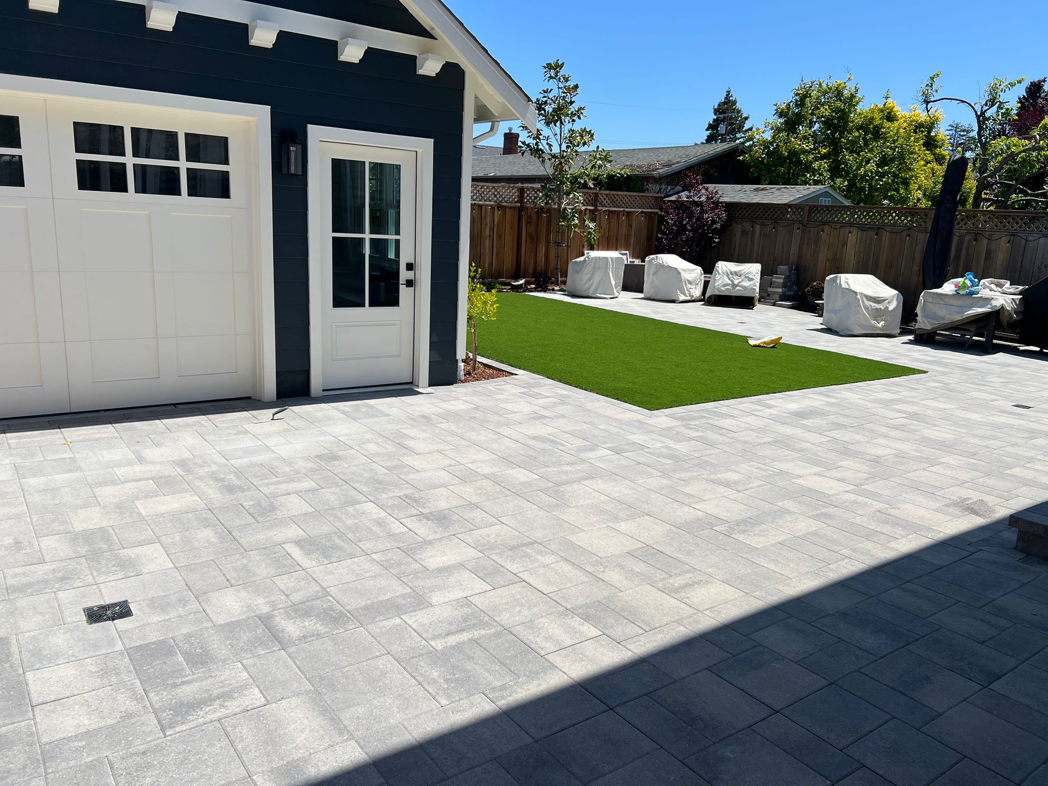 Backyard patio area with artificial turf and outdoor furniture