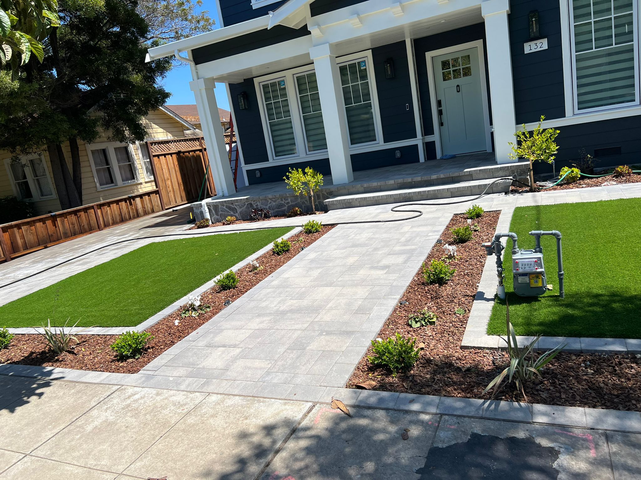 Front yard landscaping with artificial turf and paver walkway