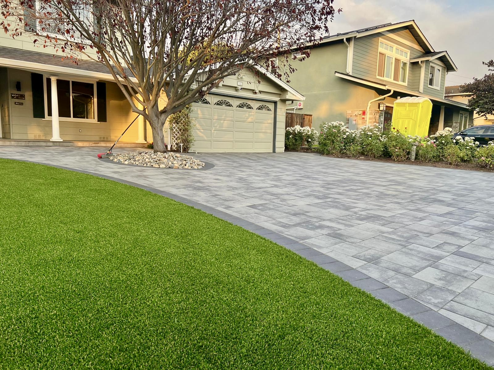 Beautiful front yard with artificial turf and paver driveway