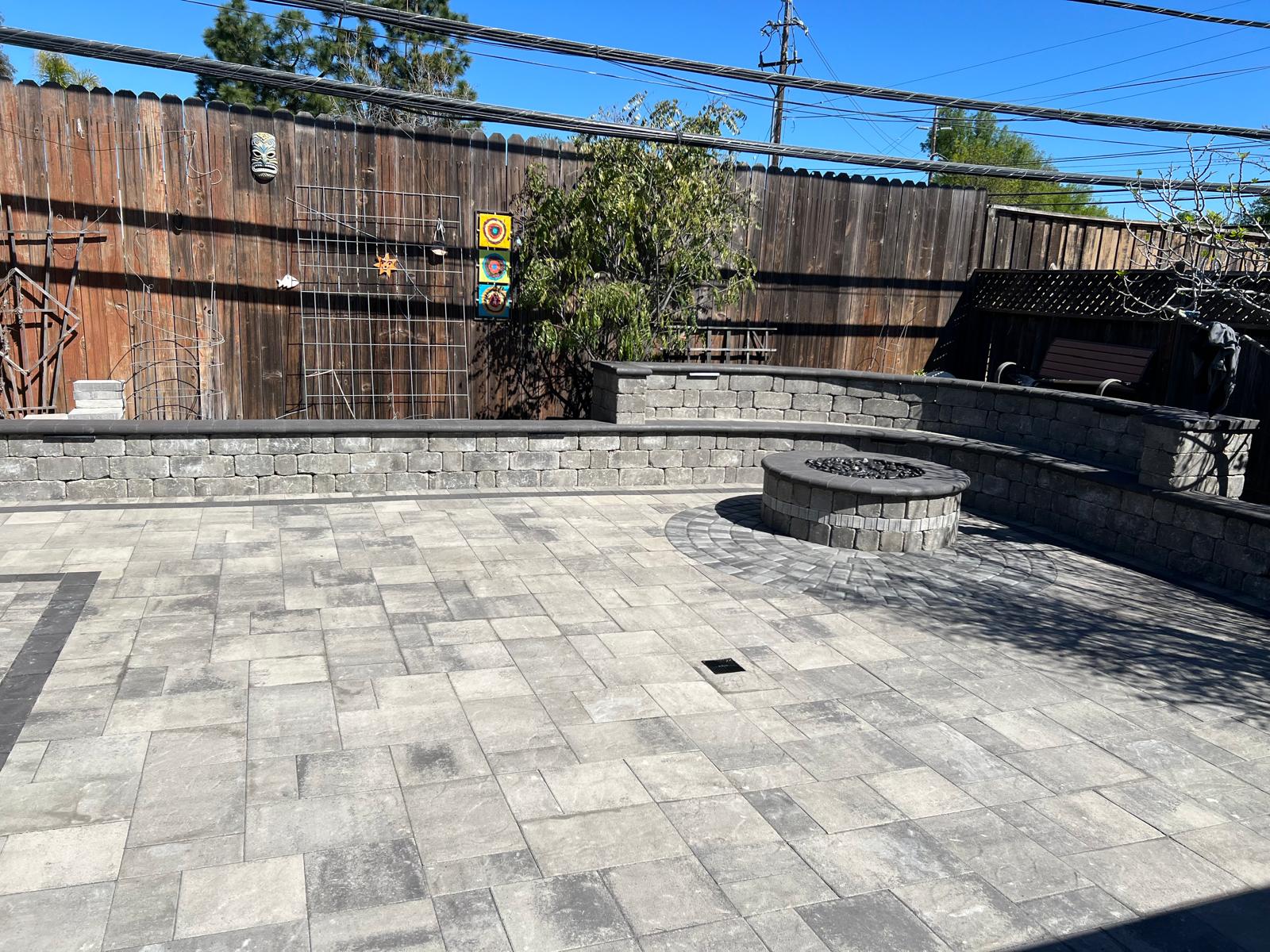 Stone patio with circular firepit and retaining walls